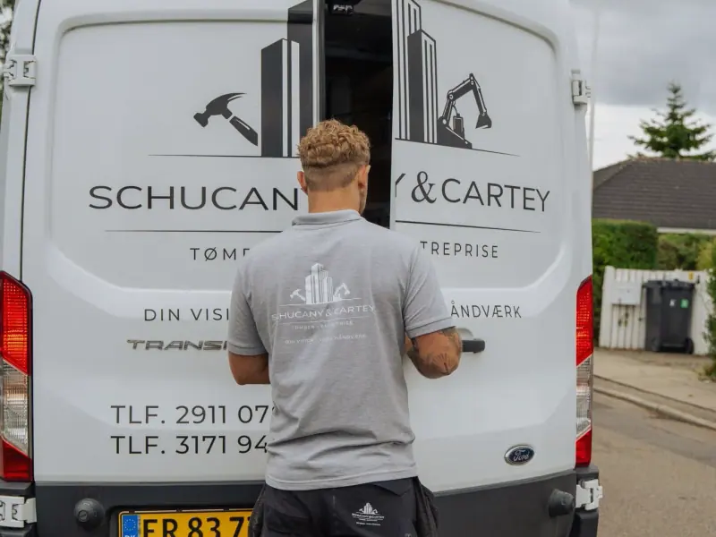 Christian Schucany åbner bagdøren på firmabilen på en villavej