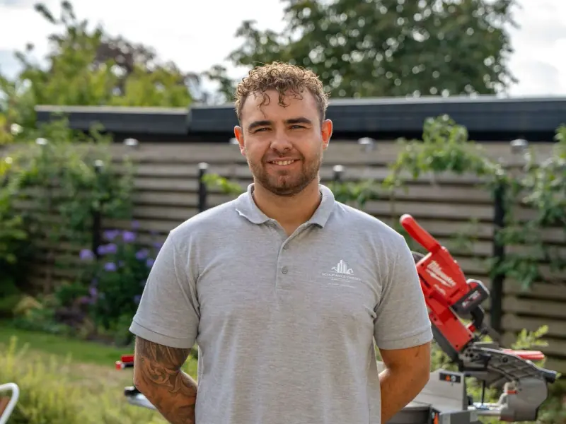 Christian Schucany i firmapolo på en arbejdsplads i en have