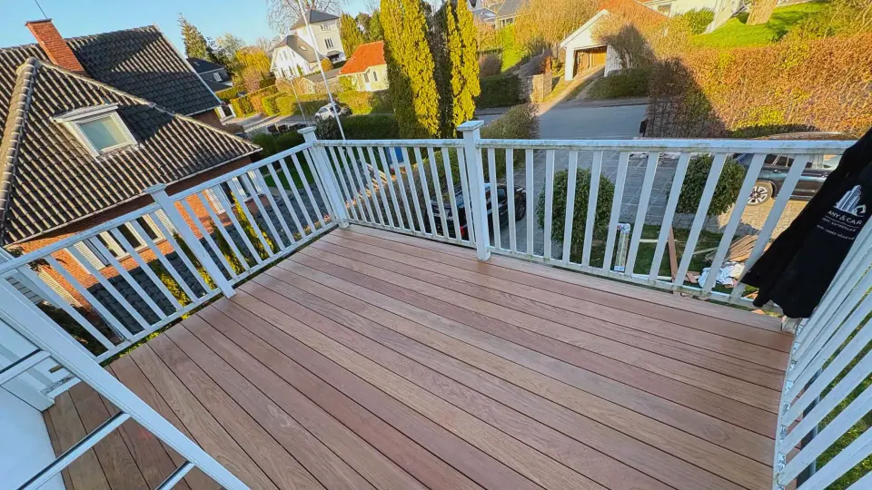 Hævet altanterrasse med værn og trappe ned til haven